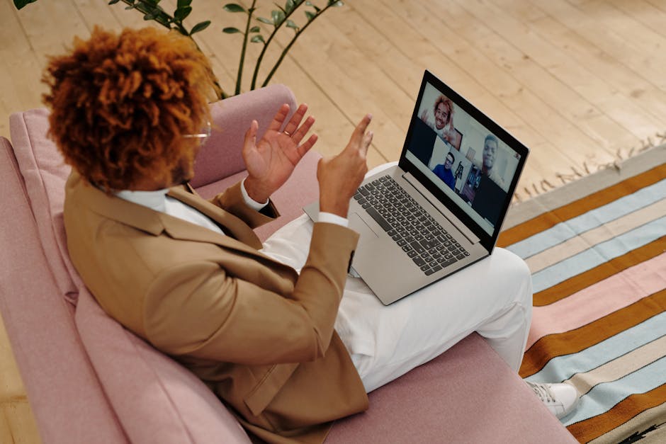 A laptop on a desk showing a video conference meeting